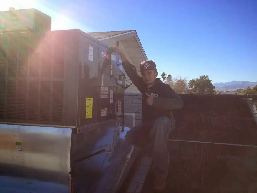 HVAC technician performing AC Tune-Up on a rooftop unit in Lincoln